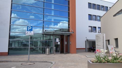 Schöneckerstraße 4, modernes mehrstöckiges Gebäude, davor Parkplatz