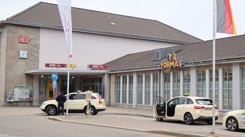 Yormas in flachem Anbau an Bahnhofsgebäude.