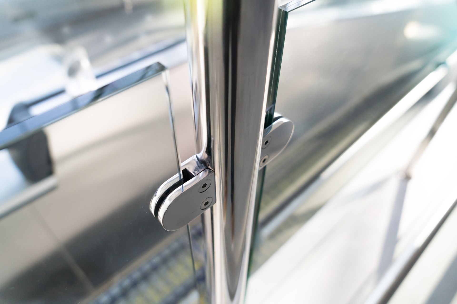 Chrome handrail and glass panel on a modern staircase or walkway