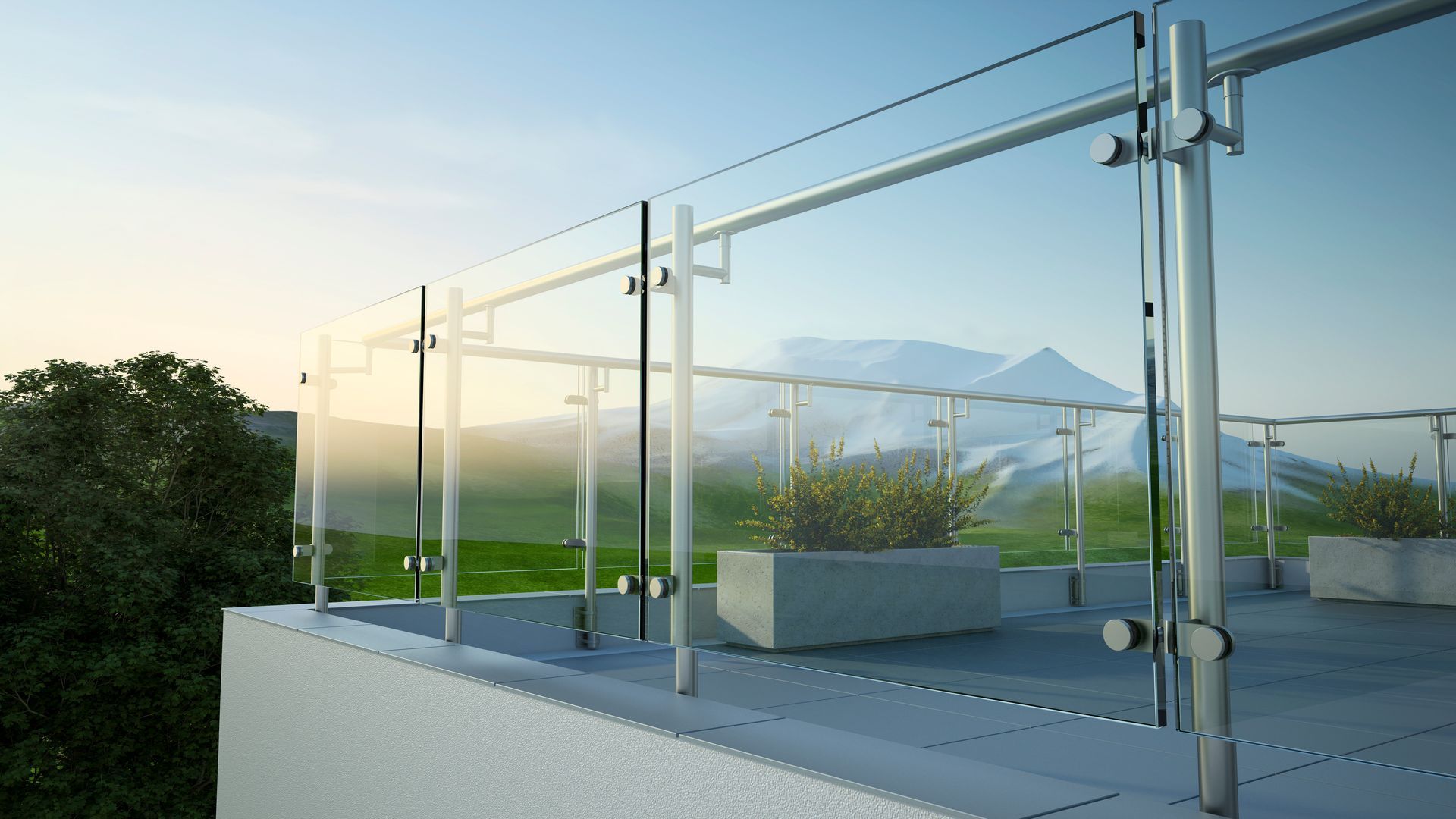 Modern glass balcony with potted plants and a mountain view at sunset