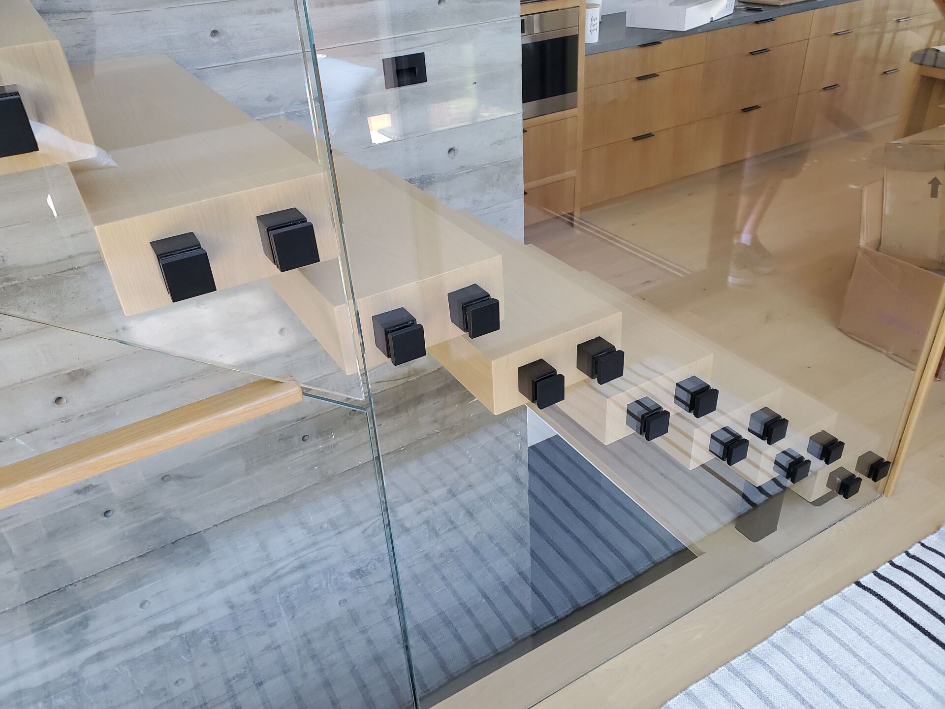 Modern interior with beige wood stairs and black cube markers on glass walls and steps Modern interior with beige wood stairs and black cube markers on glass walls and steps