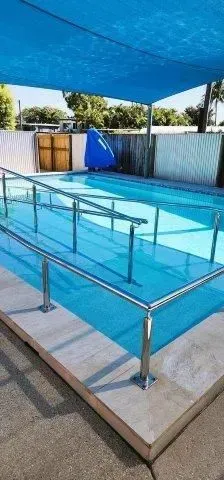 A Swimming Pool With Metal Stairs — Doug Allen Pools In Beaconsfield, QLD