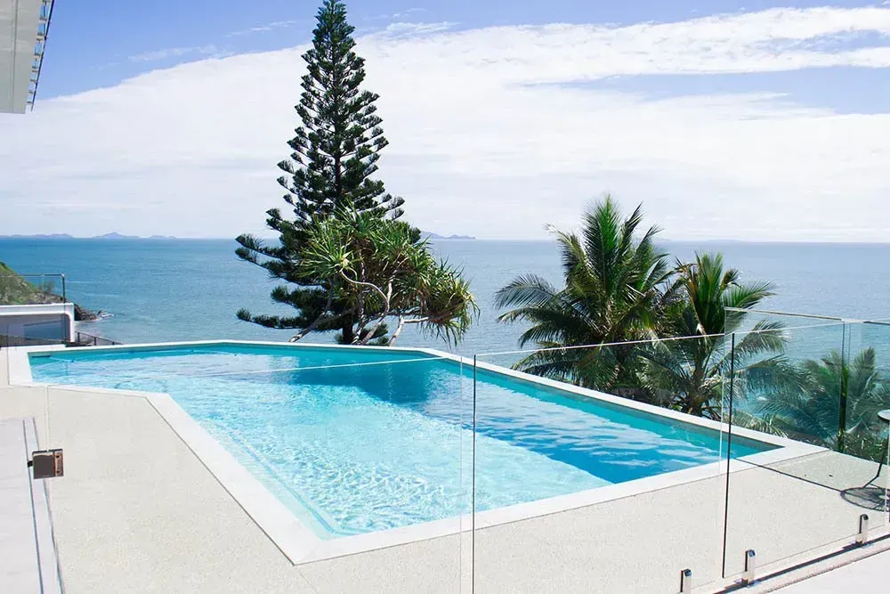 A Swimming Pool With Glass Fence In The Backyard — Doug Allen Pools In Beaconsfield, QLD