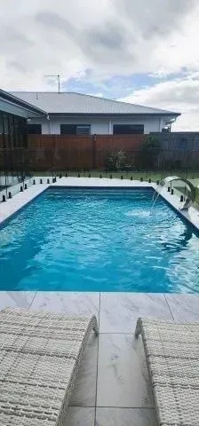 A Swimming Pool With A Waterfall Feature — Doug Allen Pools In Beaconsfield, QLD