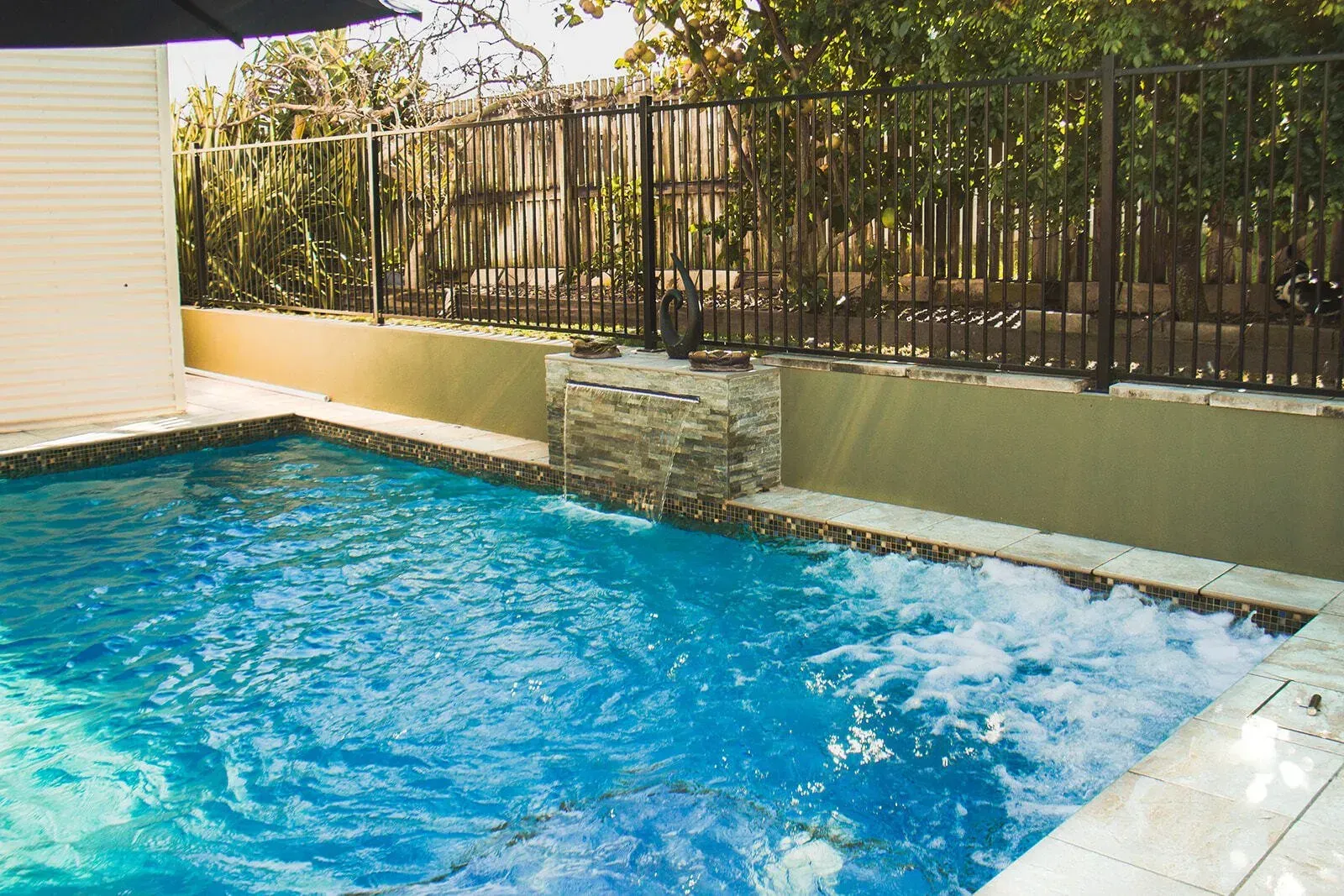 A Swimming Pool With Stone Waterfall Feature — Doug Allen Pools In Beaconsfield, QLD