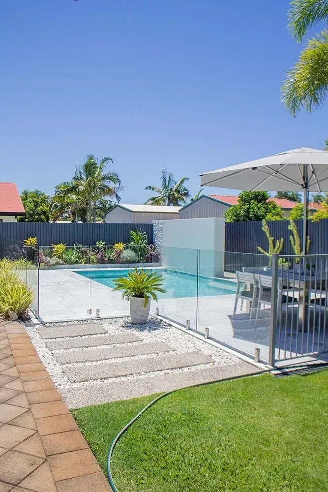 A Swimming Pool With Glass Fence In The Backyard — Doug Allen Pools In Beaconsfield, QLD