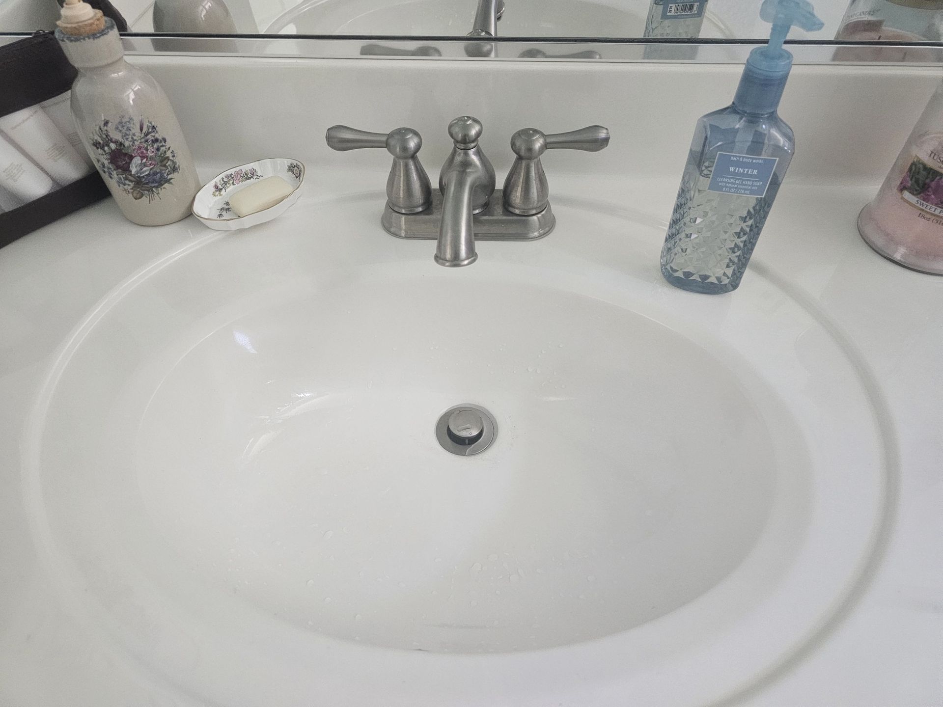 White bathroom sink with chrome faucet and soap dispenser on the counter