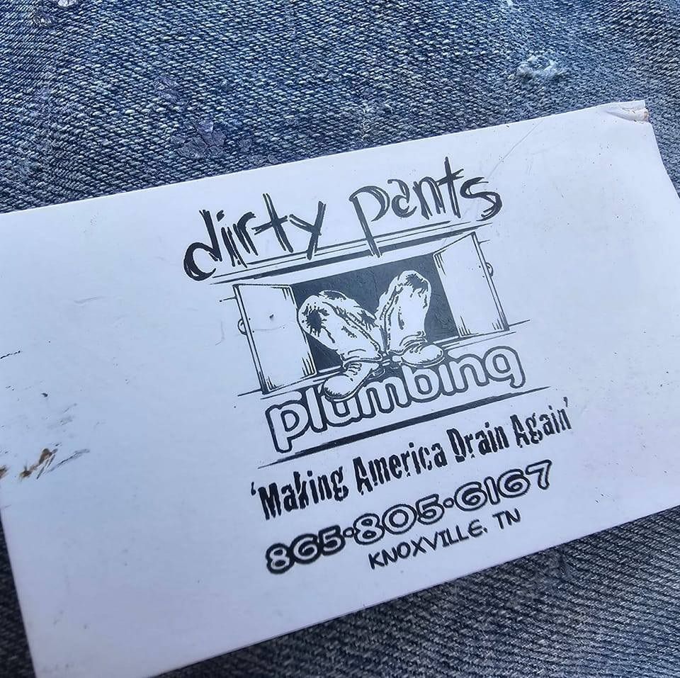 Dirty Pants Plumbing business card on blue fabric, with logo and Knoxville, TN phone number.