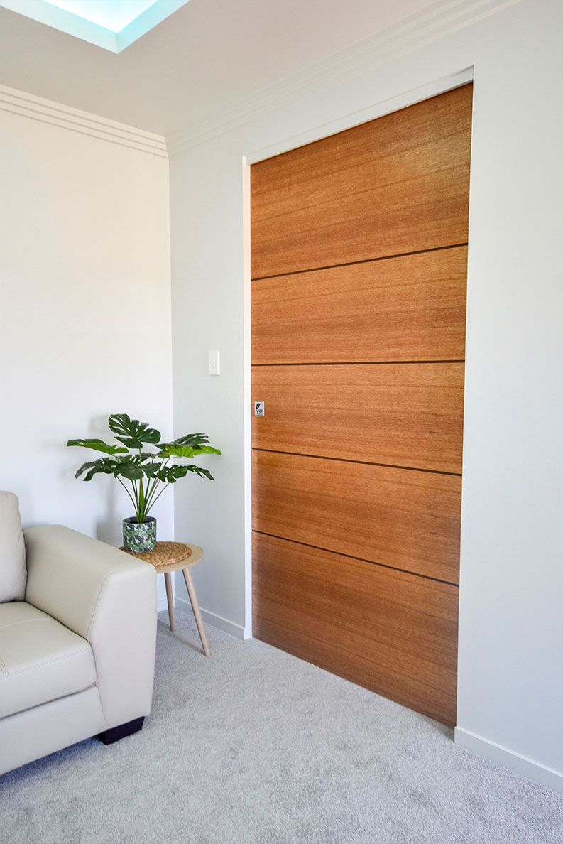 Modern Living Room with A Wooden Door — Bundy Homes in Bundaberg North, QLD