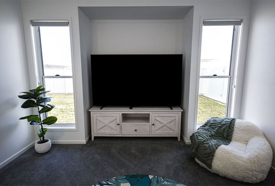 Living Room with A Large Tv, White Console and A White Bean Bag Chair — Bundy Homes in Bundaberg North, QLD