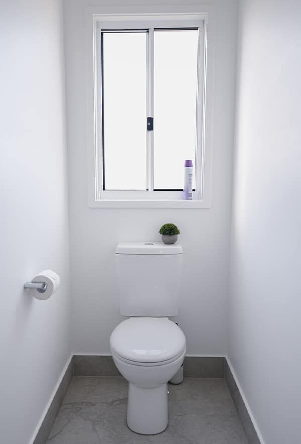 Small White Bathroom with A Toilet — Bundy Homes in Bundaberg North, QLD
