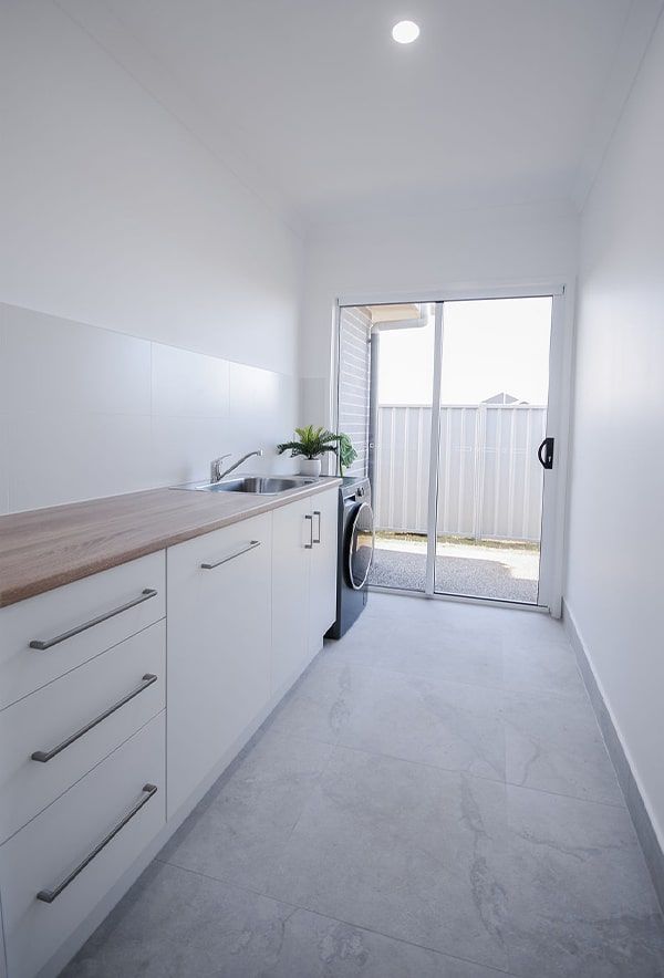 Bright Narrow Kitchen with White Cabinets — Bundy Homes in Bundaberg North, QLD