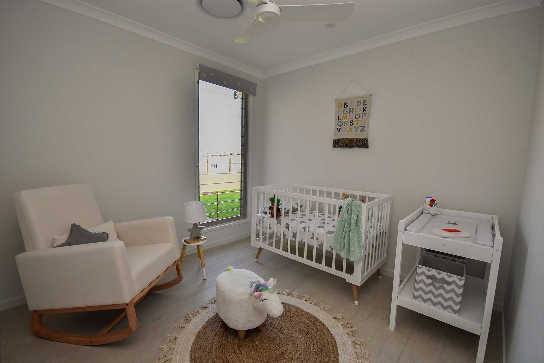 Nursery with White Crib, Rocking Chair, and Changing Table — Bundy Homes in Bundaberg North, QLD