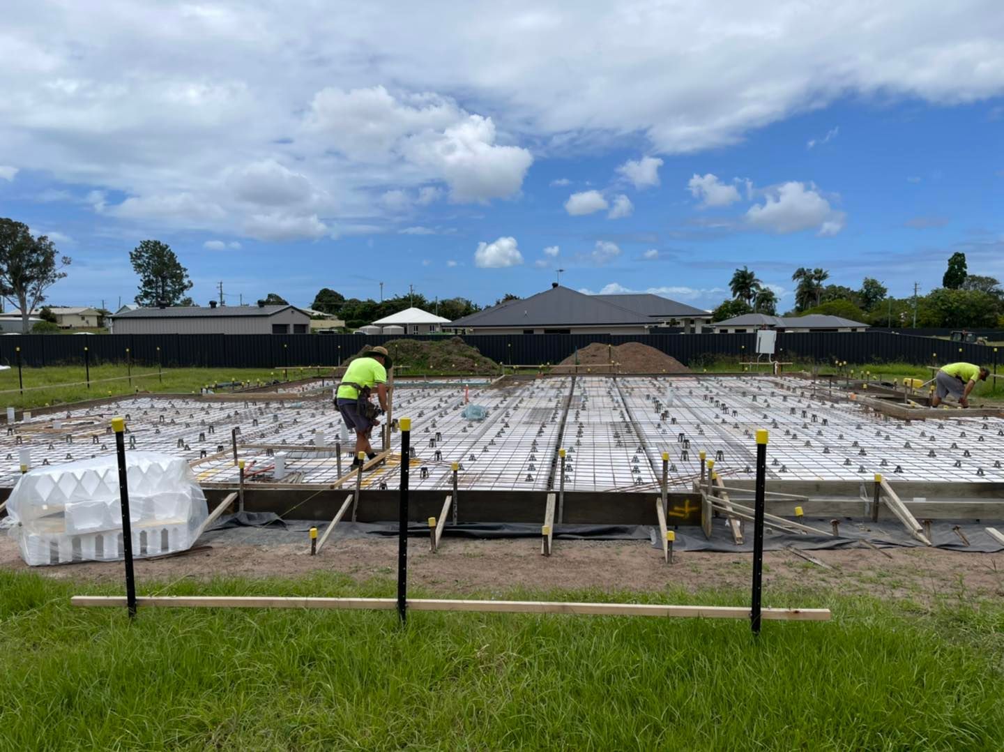 Person in Neon Vest Working Over a Large White-Covered Field — Bundy Homes in Bundaberg North, QLD