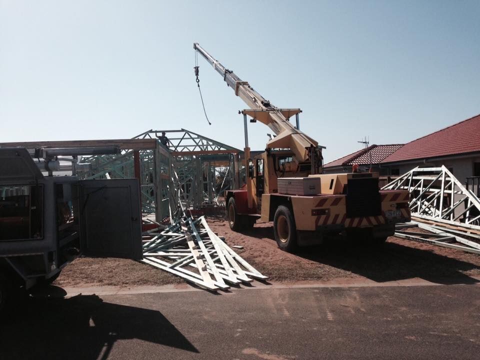 Construction Vehicle Lifting Steel Roof Trusses at A Building Site — Bundy Homes in Bundaberg North, QLD