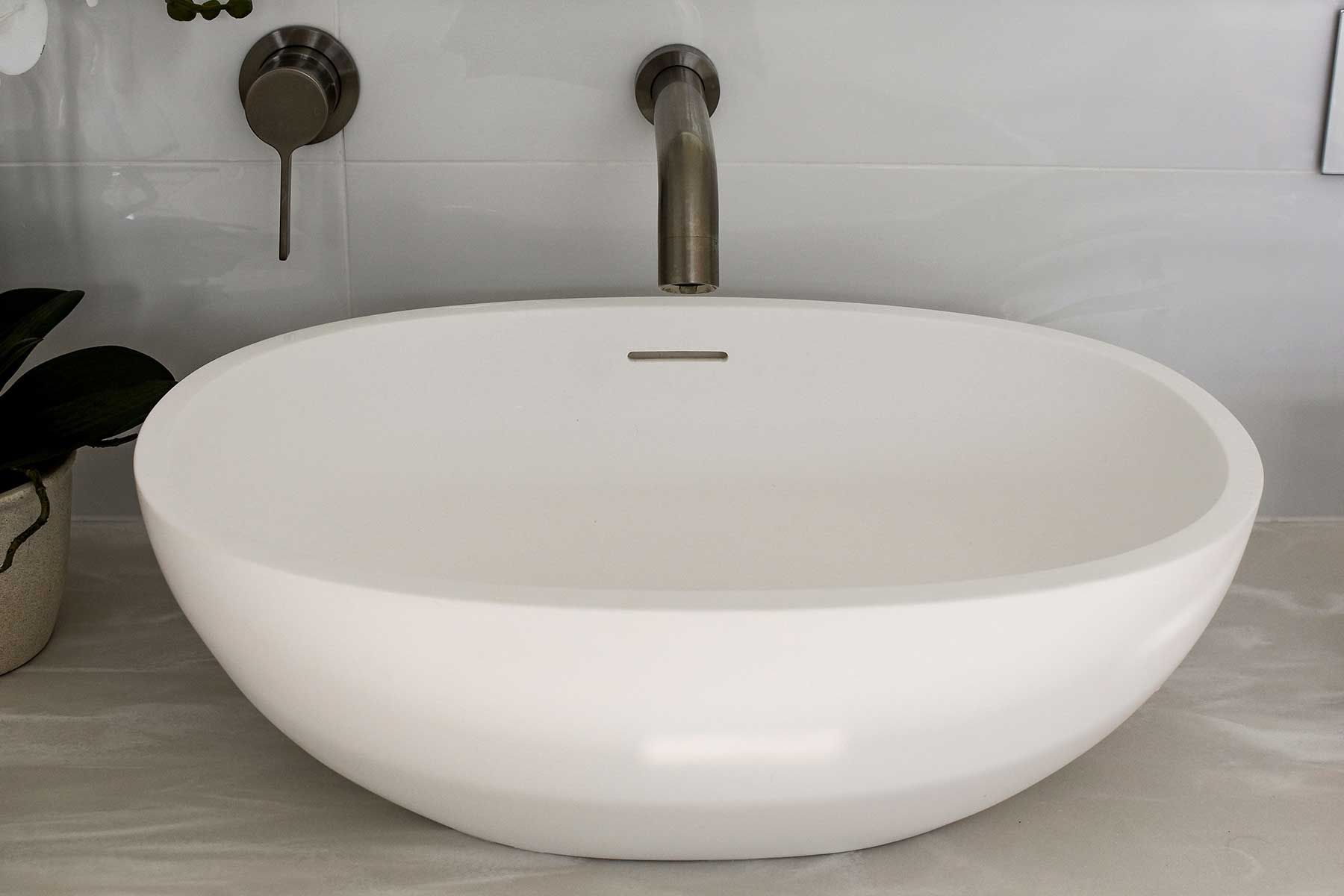 White Oval Bathroom Vessel Sink with Chrome Faucet on A Light Countertop — Bundy Homes in Bundaberg North, QLD
