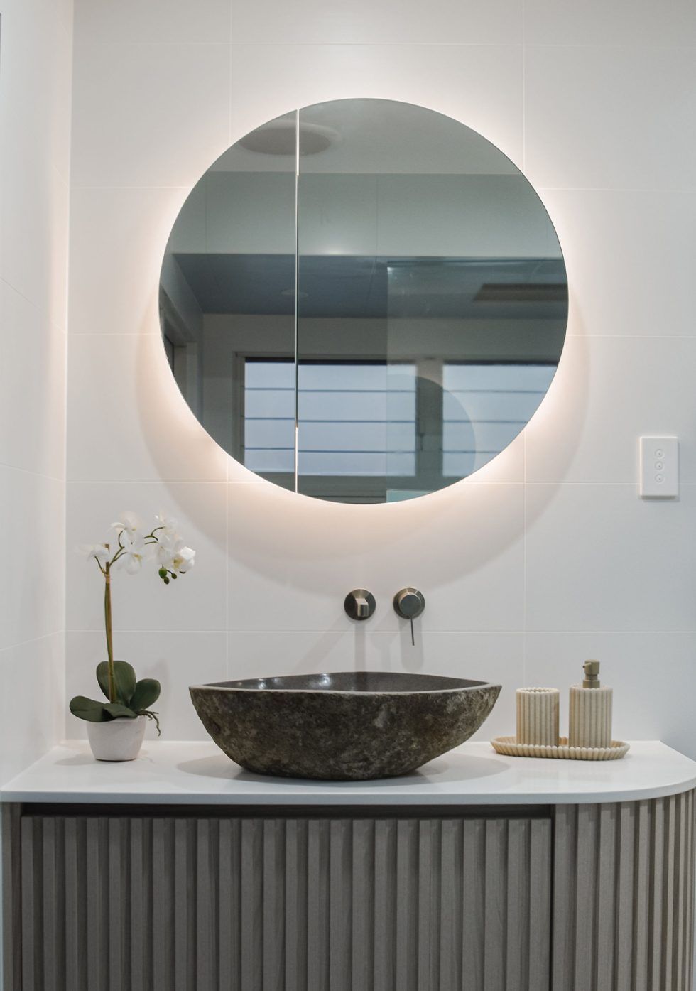 Modern Bathroom Vanity with Round Illuminated Mirror — Bundy Homes in Bundaberg North, QLD