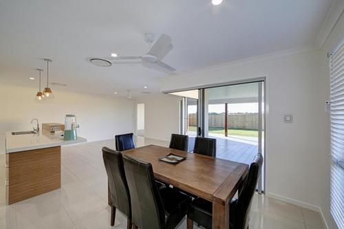 Bright Open Dining Room and Kitchen with Wooden Table — Bundy Homes in Bundaberg North, QLD