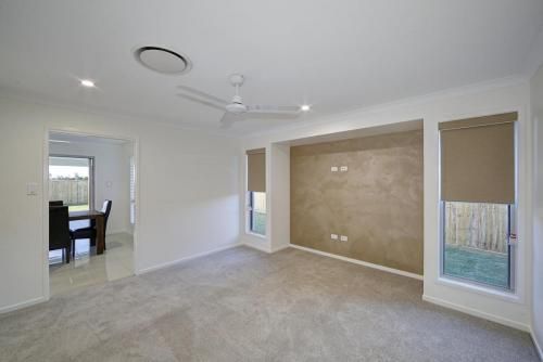 Empty Beige Living Room with Carpet — Bundy Homes in Bundaberg North, QLD