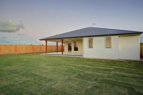Modern White House with Dark Roof and Covered Patio — Bundy Homes in Bundaberg North, QLD