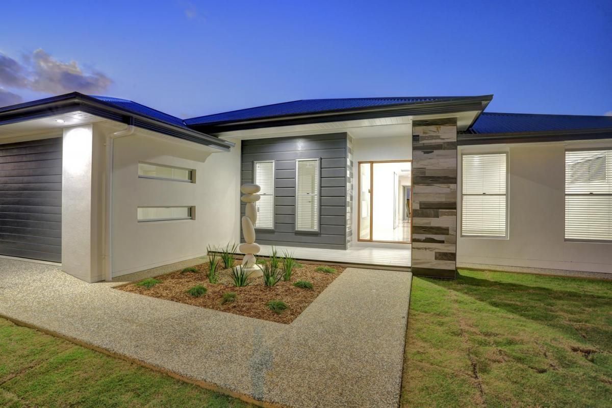 Modern Single-Story House Exterior at Dusk with Lit Entryway — Bundy Homes in Bundaberg North, QLD