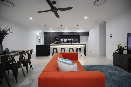Modern Open-Plan Living Room with Orange Sofa — Bundy Homes in Bundaberg North, QLD
