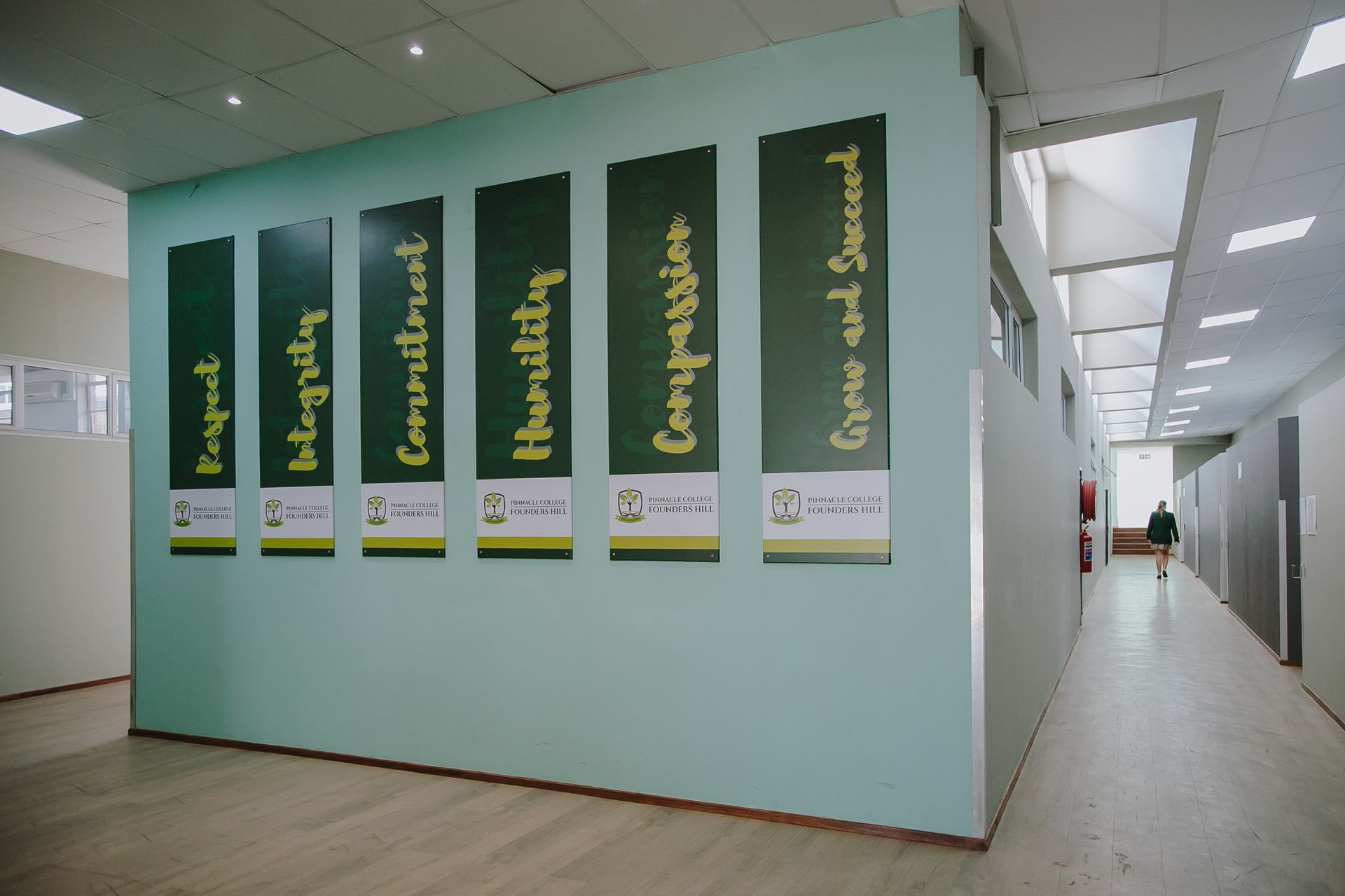 A person is walking down a hallway with signs on the wall.