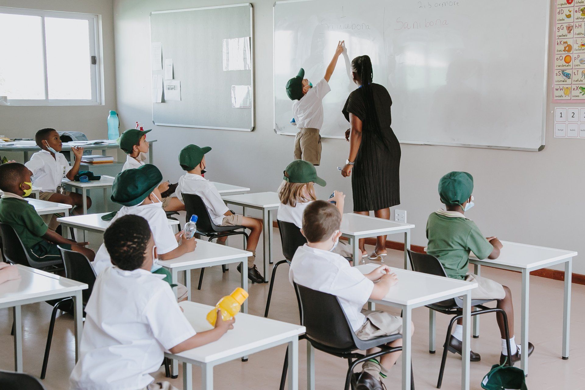 A teacher is giving a high five to a student in a classroom.