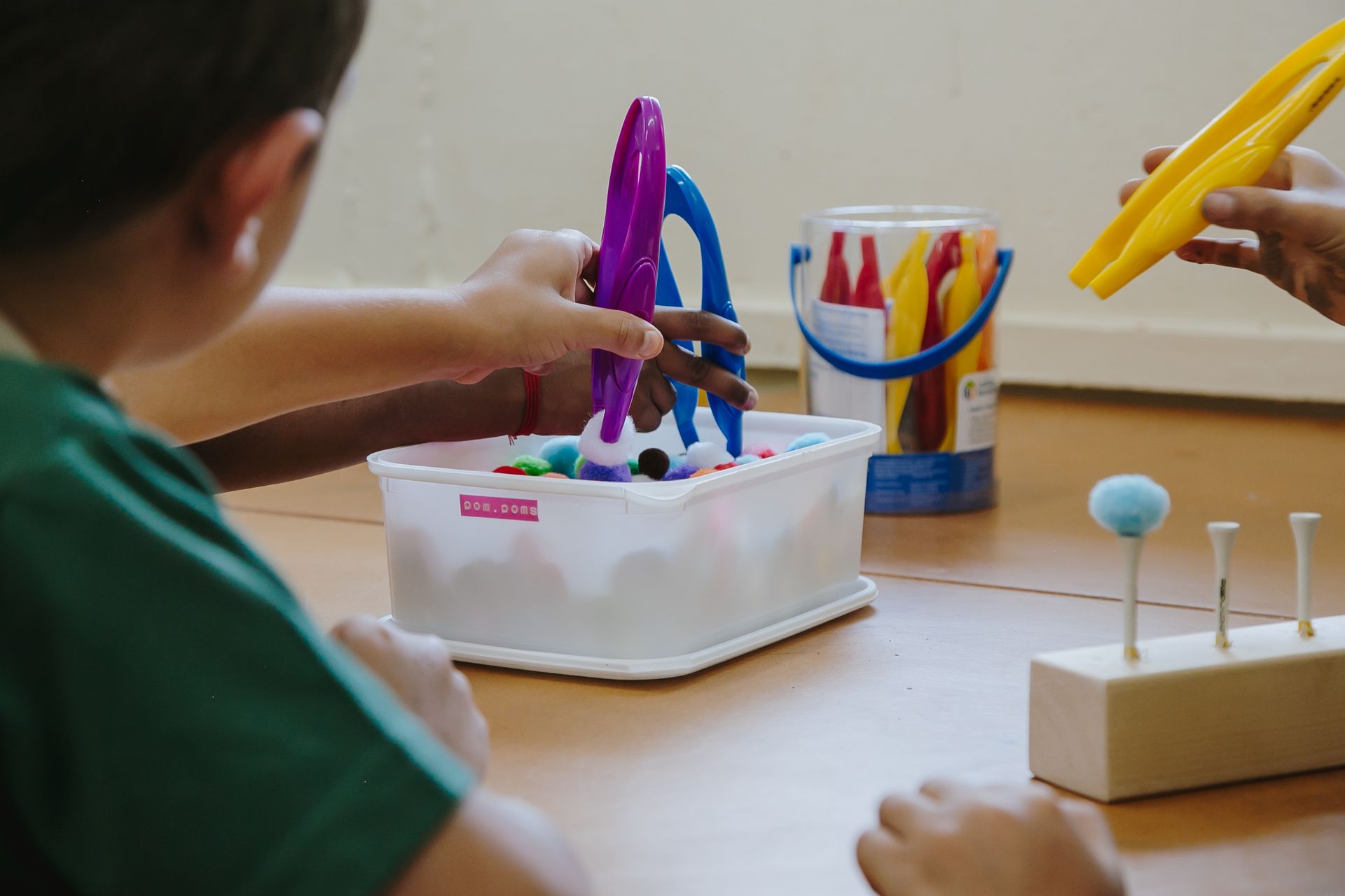 A child is playing with a pair of scissors on a table