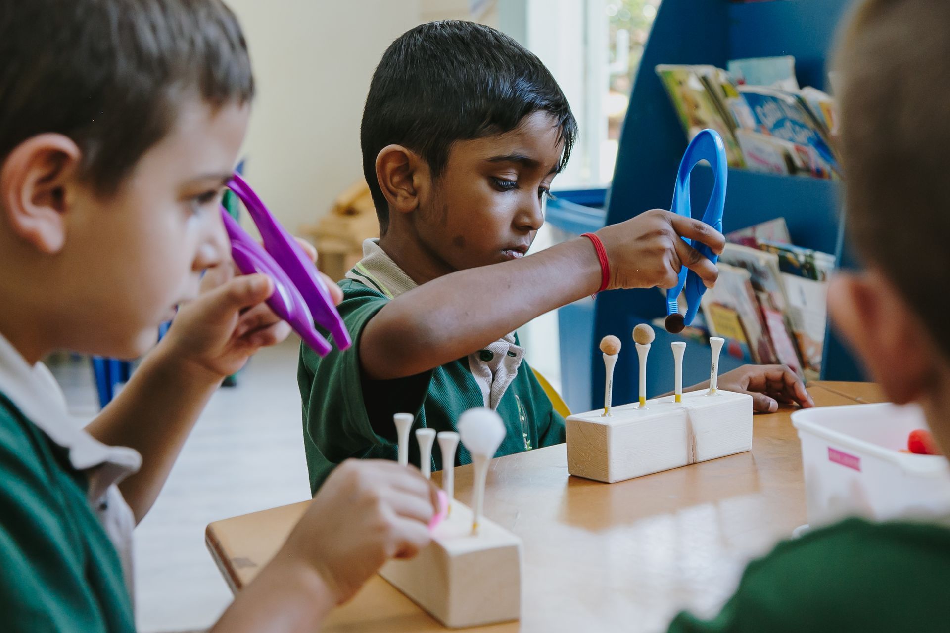 A group of children are sitting at a table playing with toys.