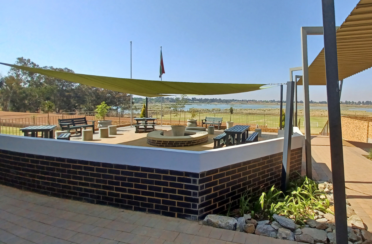 A brick building with a green umbrella on top of it.