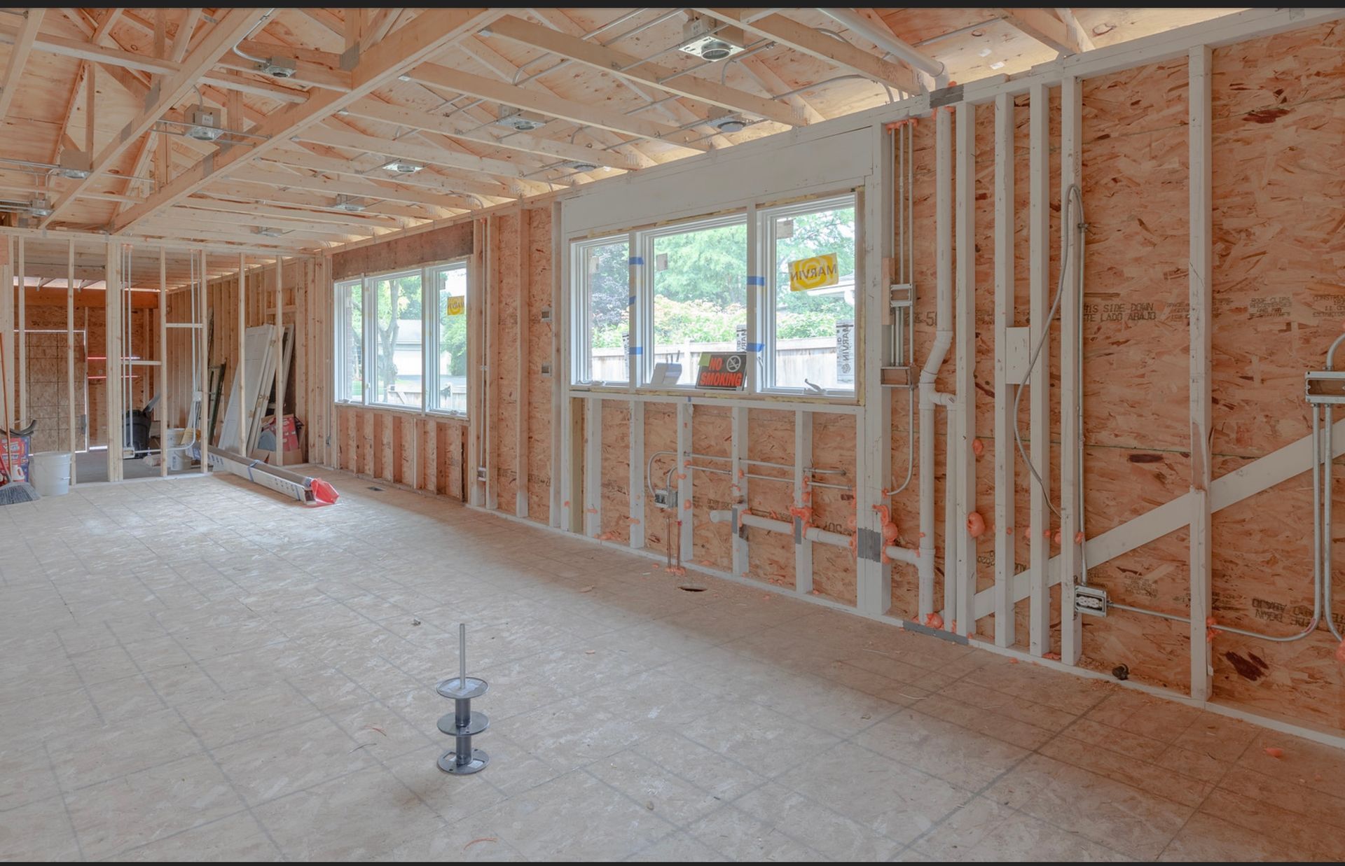 A man is standing in a room under construction.