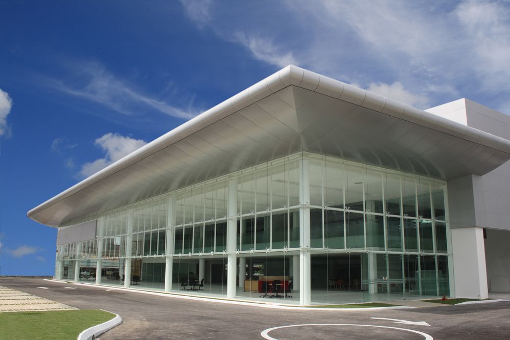 A Large Building with A Lot of Windows and A Car Parked in Front of It — Croker Building Solutions In Myrtleville, NSW
