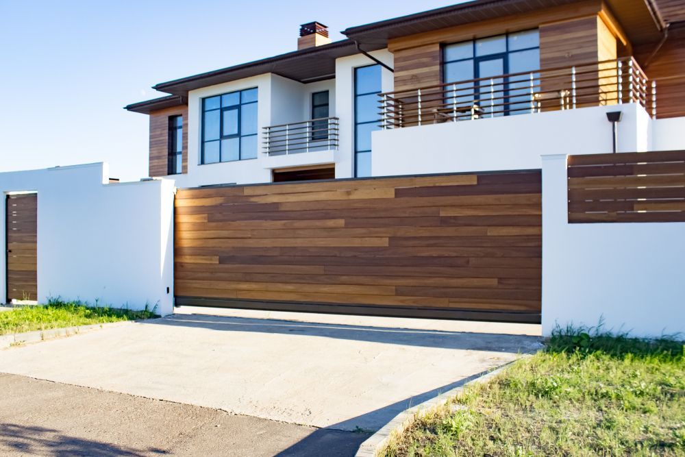 A Large House with A Wooden Fence and Sliding Garage Door — Croker Building Solutions In Myrtleville, NSW