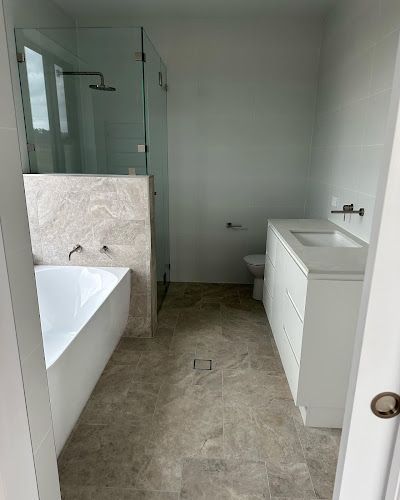 A bathroom with a bathtub , sink , toilet and shower. — Croker Building Solutions In Myrtleville, NSW