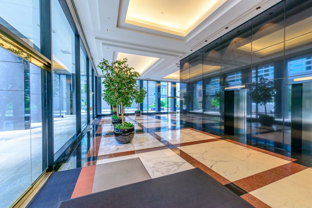 A Large Lobby with A Lot of Windows and A Tree in The Middle — Croker Building Solutions In Myrtleville, NSW