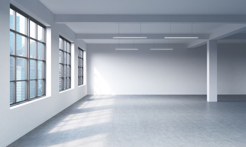 An Empty Room with A Lot of Windows and A Concrete Floor — Croker Building Solutions In Myrtleville, NSW