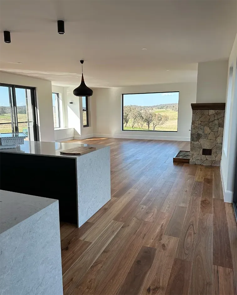 A large empty room with hardwood floors and a fireplace. — Croker Building Solutions In Myrtleville, NSW