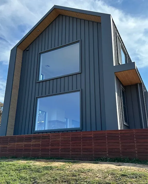 A large house with a lot of windows and a wooden fence in front of it. — Croker Building Solutions In Myrtleville, NSW