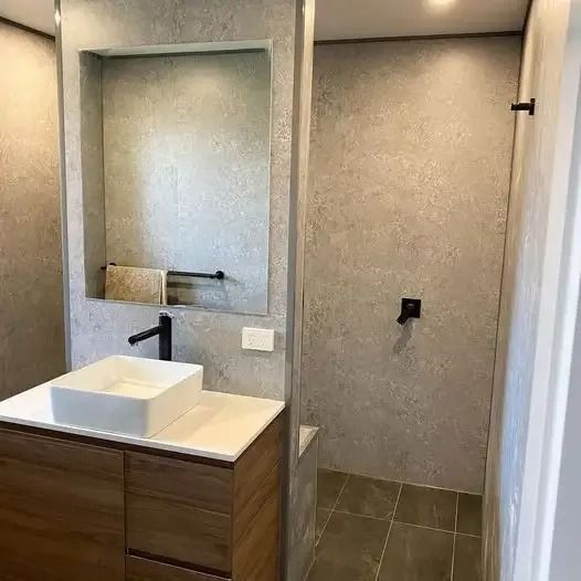 A bathroom with a sink , mirror and shower. — Croker Building Solutions In Myrtleville, NSW