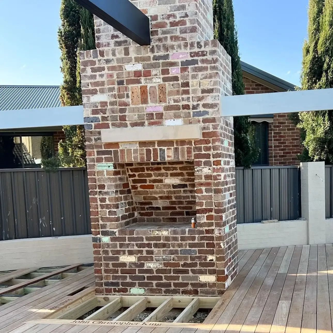 A Large Brick Chimney Is Sitting on A Wooden Deck — Croker Building Solutions In Myrtleville, NSW