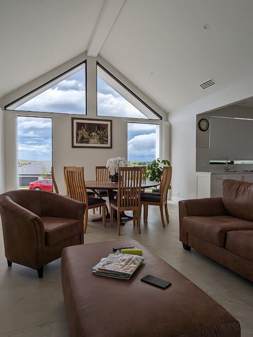 A living room with a couch , chairs , table and ottoman. — Croker Building Solutions In Myrtleville, NSW