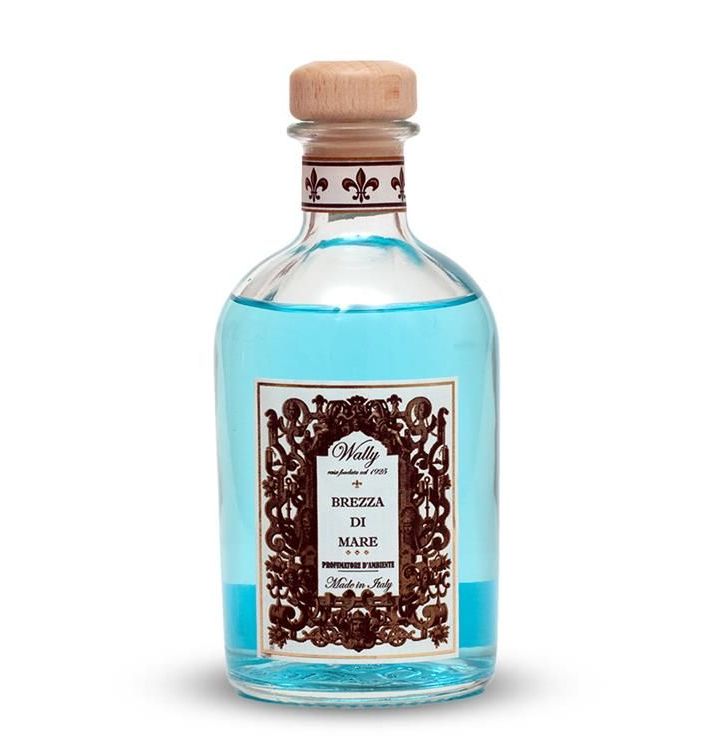 Una bottiglia di liquido blu con etichetta decorativa e tappo di legno.