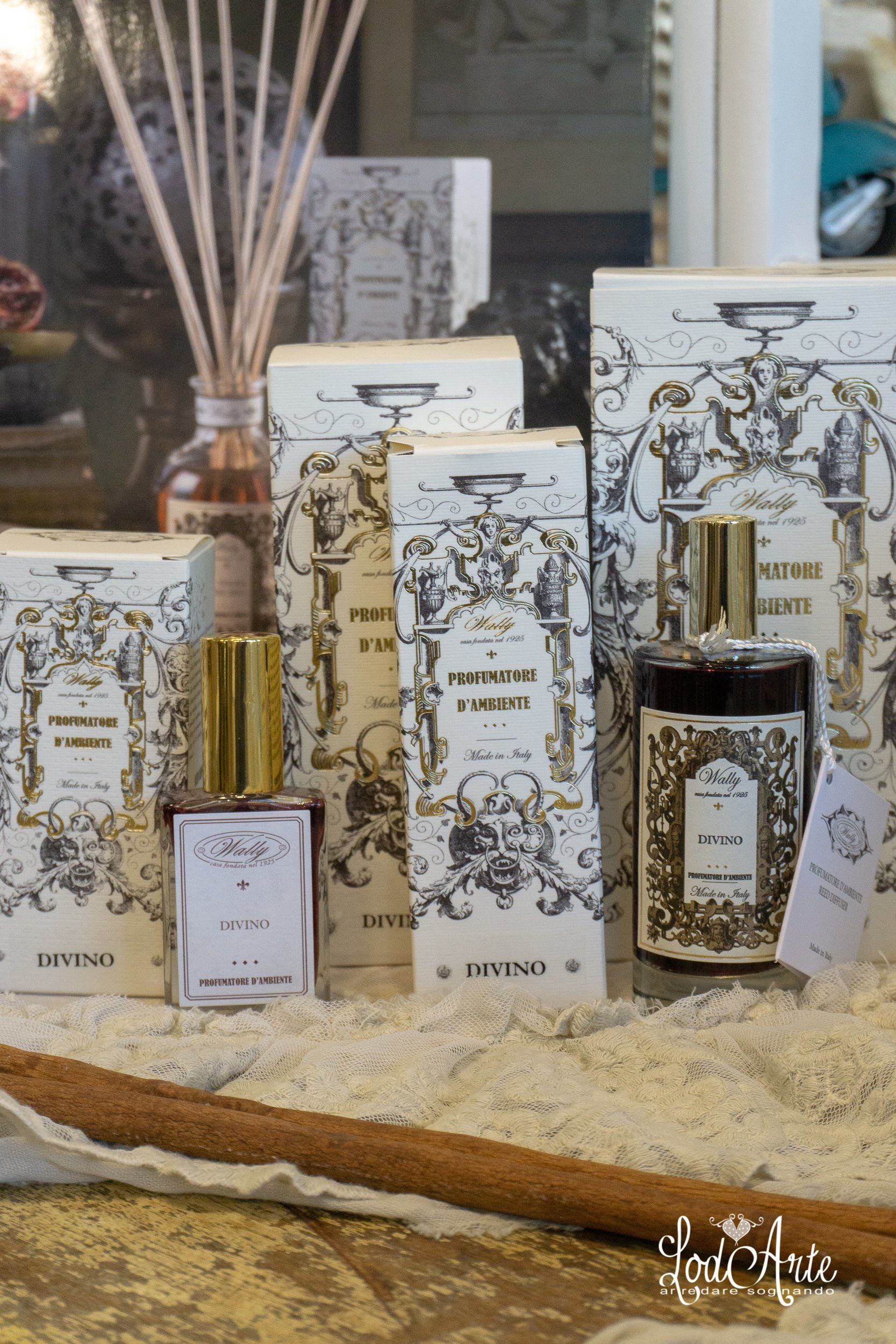 Flaconi di profumo e diffusori con confezione decorativa su una superficie bianca.