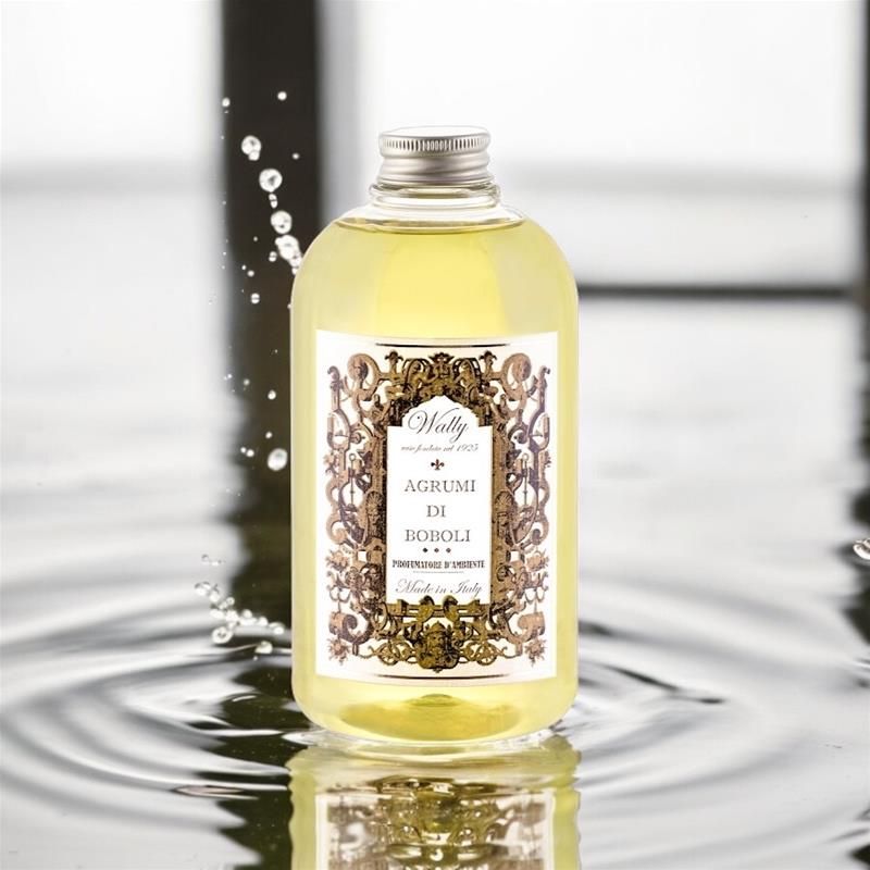 Flacone di profumo Agrumi di Sicilia con gocce d'acqua e increspature.