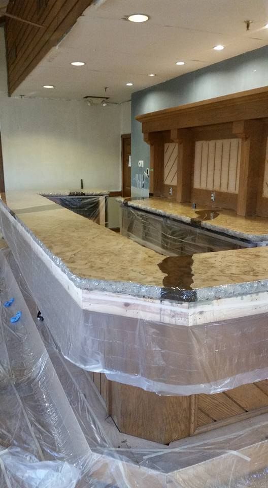 A bar is being built in a restaurant and is covered in plastic.
