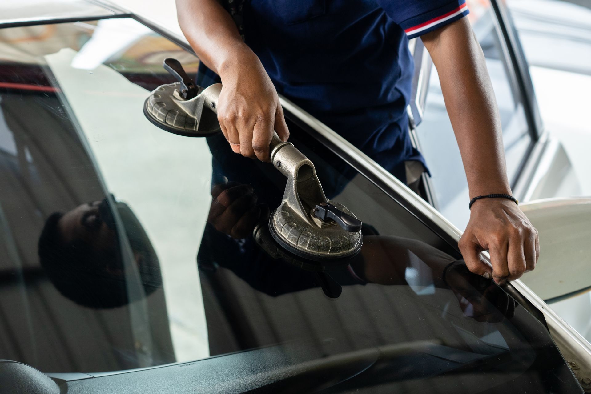 Person using a suction cup tool to repair or replace a car windshield
