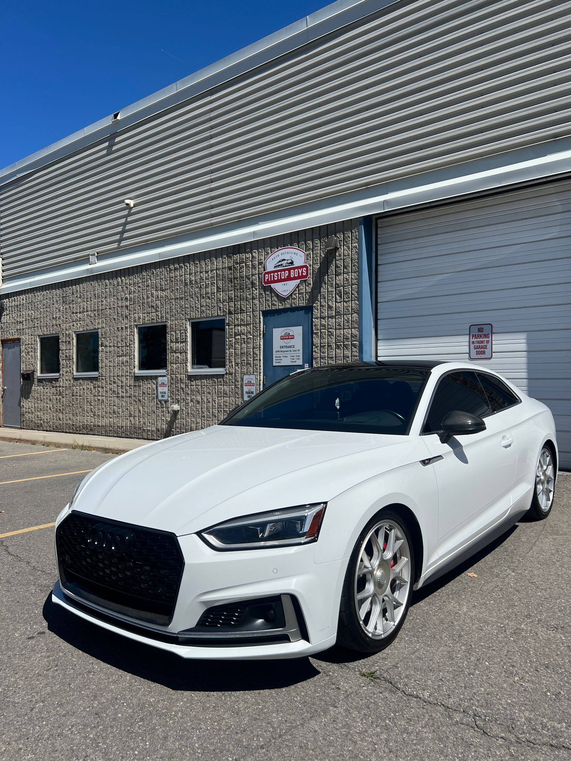 White sedan parked outside a building on a sunny day