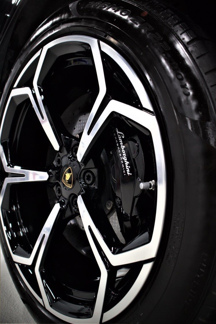Close-up of a black car wheel with white-accented alloy rim and visible tire tread