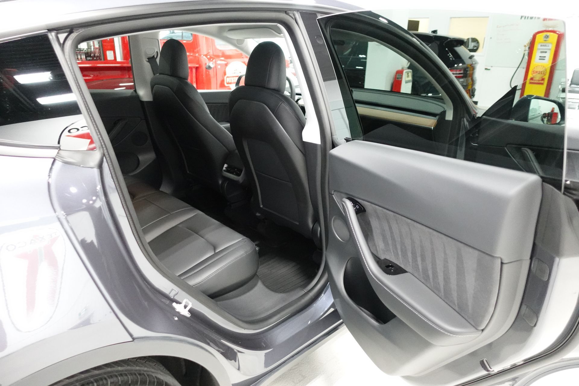 Open rear door of a silver SUV, showing black seats and gray interior trim